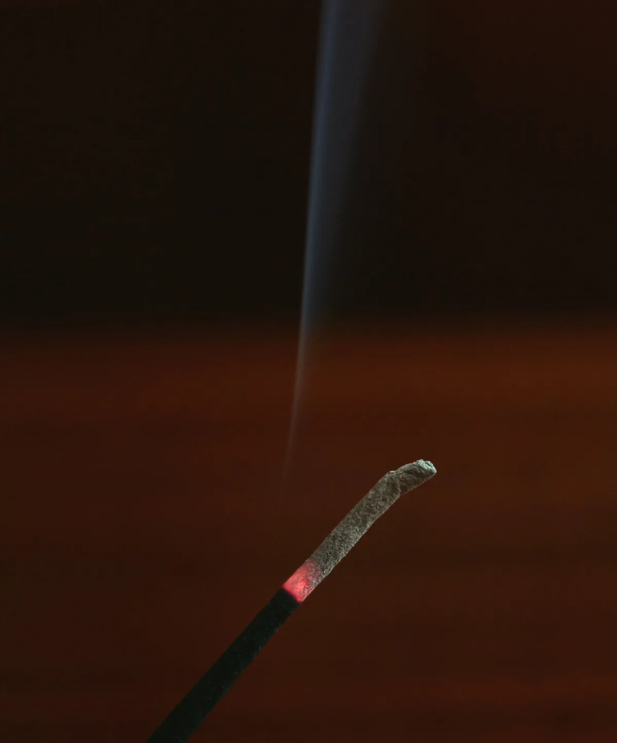 Incense smoke streaming sideways toward an attic access panel